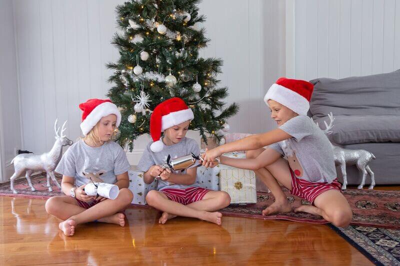 3 kids opening Christmas crackers